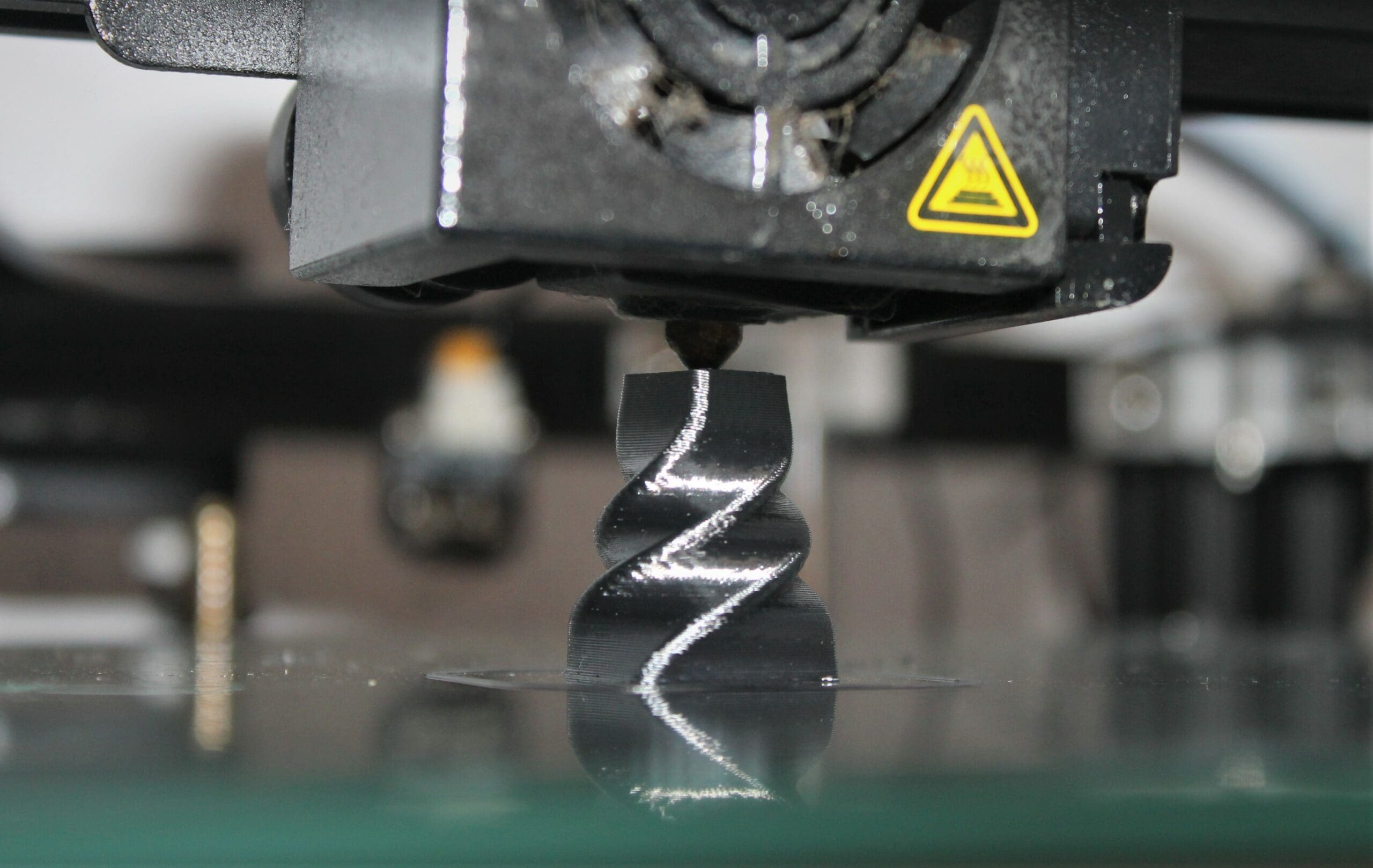 a 3D printing machine creates a twisted steel chess piece