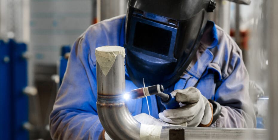 A person welds a pipe